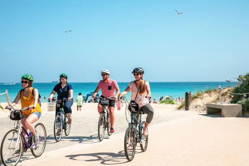 Grupo de amigos en bicicleta por el paseo marítimo junto al mar en Malgrat de Mar